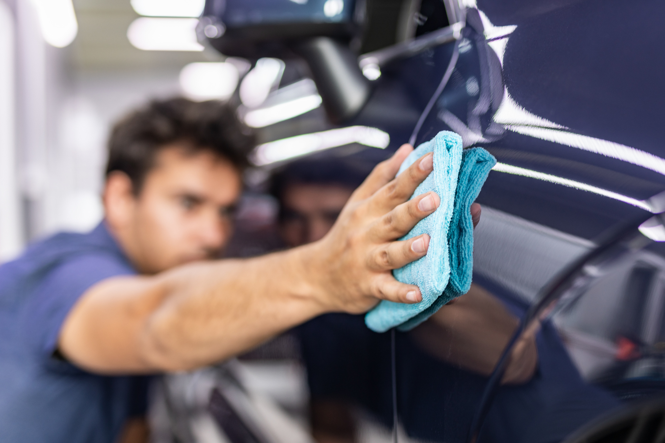 Man Cleaning and Polishing Car 